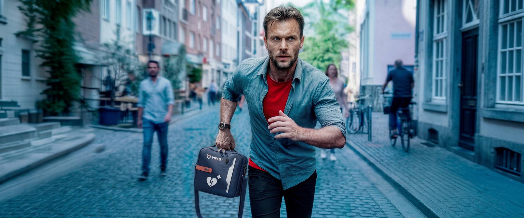 Man rent met AED-tas door een winkelstraat — elke seconde telt